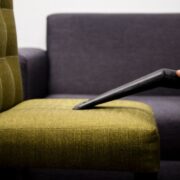 Stoffen fauteuil wordt van dichtbij gestofzuigd met een meubelmondstuk om kruimels en stof te verwijderen